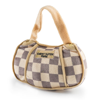 Two plush dog toys designed like Chewy Vuiton Paris handbags, featuring a beige and grey checkered pattern with soft handles, shown in large and small sizes.