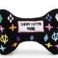 Black plush dog bone toy with colorful embroidered designer-style icons and a “Chewy Vuiton Paris” label. Soft luxury squeaky chew toy for pets.