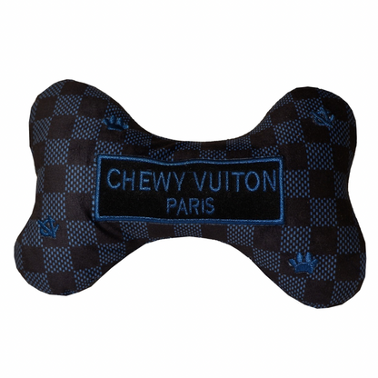 Plush dog bone toy in black and blue check pattern with blue embroidered icons and a “Chewy Vutton Paris” label. Luxury designer-style squeaky chew toy for pets.