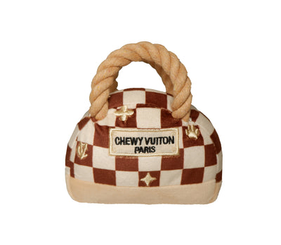 Luxury plush dog handbag toy with brown check pattern, rope-style handles, and “Chewy Vutton Paris” label. Soft squeaky designer-style chew toy for pets.