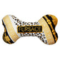 Plush dog bone toy with black, gold, and leopard print pattern featuring a gold embroidered “Fursace” label. Luxury designer-style squeaky chew toy for pets.